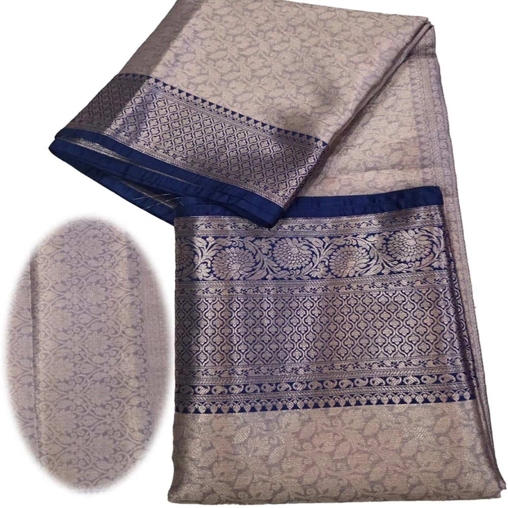 Detailed view of the embossed floral patterns and metallic gold zari weaving on a light blue tissue silk saree
