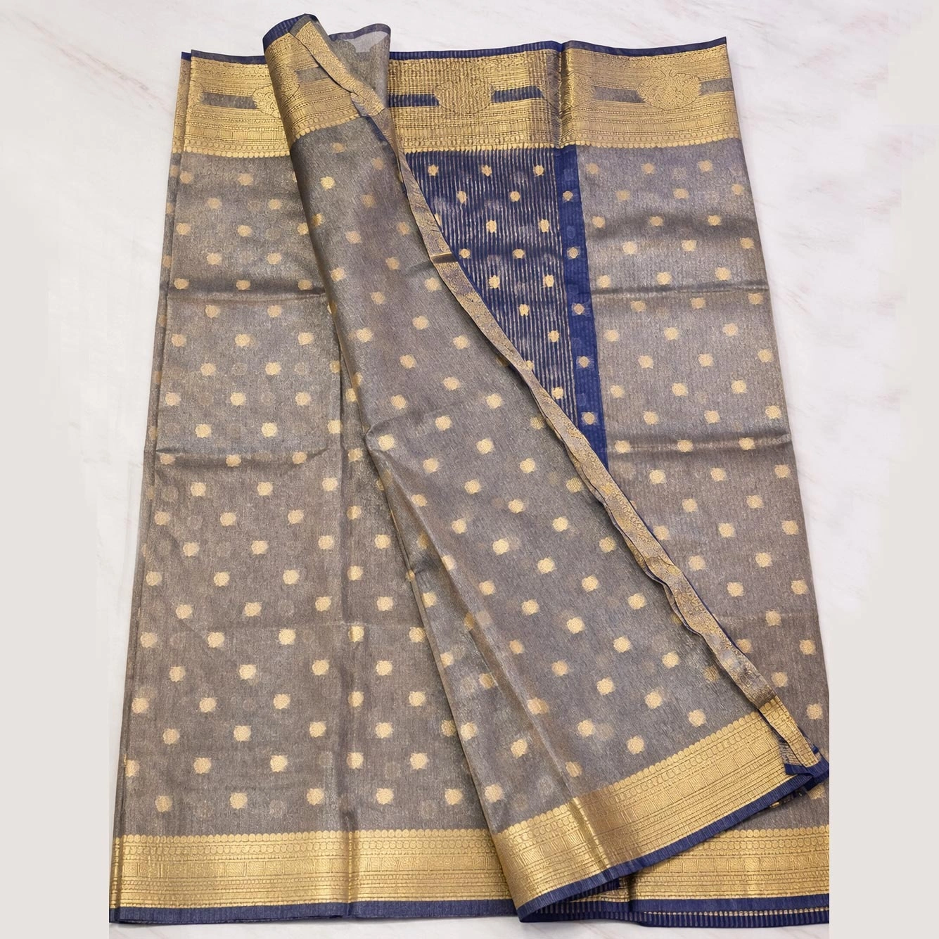 Styling inspiration for a blue Banarasi tissue saree featuring a modern party background.